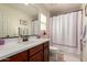 Bright bathroom with a single sink vanity, framed mirror and combined shower and bathtub at 1217 W Fever Tree Ave, San Tan Valley, AZ 85140