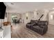 Spacious living area featuring a large leather sofa, wood-style tile flooring, and stairs to the second level at 1217 W Fever Tree Ave, San Tan Valley, AZ 85140