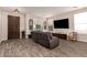 Open-concept living area with wood-style flooring, a cozy leather sofa, and abundant natural light at 1217 W Fever Tree Ave, San Tan Valley, AZ 85140