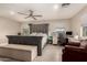 Bright main bedroom with a ceiling fan, wood-look flooring, home office space, and a gray headboard at 1217 W Fever Tree Ave, San Tan Valley, AZ 85140