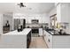 Modern kitchen with white cabinets, stainless steel appliances, and a center island with quartz countertops at 12271 N 74Th St, Scottsdale, AZ 85260