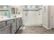 Bathroom with a large glass shower, gray cabinets, and wood-look tile floors at 1228 W Snowbell Ave, Queen Creek, AZ 85140