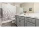Bathroom with gray vanity, framed mirror, shower with decorative curtain, and wood-look flooring at 1228 W Snowbell Ave, Queen Creek, AZ 85140