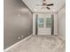 Bedroom with gray walls, ceiling fan, large windows with drapes, and carpet floors at 1228 W Snowbell Ave, Queen Creek, AZ 85140