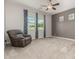 Well-lit bedroom with neutral walls and carpeted floors and a cozy gray armchair at 1228 W Snowbell Ave, Queen Creek, AZ 85140