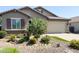 Lovely single-story home with a well-maintained front yard showcasing desert rock and plants at 1228 W Snowbell Ave, Queen Creek, AZ 85140