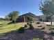 Well-manicured front yard with lush landscaping, mature trees, and a charming single-story home at 1228 W Snowbell Ave, Queen Creek, AZ 85140