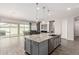Open-concept kitchen featuring granite counters, stainless steel appliances and a large island at 1228 W Snowbell Ave, Queen Creek, AZ 85140