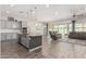 Open concept living area with a large kitchen island and comfortable living room furniture at 1228 W Snowbell Ave, Queen Creek, AZ 85140