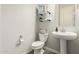 Charming powder room with pedestal sink, decorative shelves, and modern fixtures at 1228 W Snowbell Ave, Queen Creek, AZ 85140