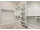 Spacious walk-in closet featuring built-in shelves and ample hanging space for optimal organization at 1228 W Snowbell Ave, Queen Creek, AZ 85140