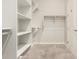 Bright walk-in closet with shelving, hanging racks, and neutral carpet flooring at 1228 W Snowbell Ave, Queen Creek, AZ 85140