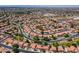 Expansive aerial view of a residential neighborhood with mature trees, red-tile roofs, and a school in the distance at 12748 N 57Th Dr, Glendale, AZ 85304