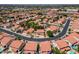 An aerial view of a residential neighborhood featuring red-tile roofs, manicured lawns, and mature trees at 12748 N 57Th Dr, Glendale, AZ 85304