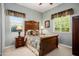 Cozy bedroom with a decorative headboard, side tables and lamps, and a sun-filled window at 12904 W Dale Ln, Peoria, AZ 85383