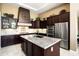 Gourmet kitchen with stainless steel appliances, custom cabinetry, and a large island sink at 12904 W Dale Ln, Peoria, AZ 85383