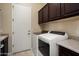 Laundry room with cabinets, sink, and modern washer and dryer units at 12904 W Dale Ln, Peoria, AZ 85383