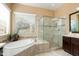 Well-lit bathroom featuring a tub, walk-in shower, and modern fixtures at 12904 W Dale Ln, Peoria, AZ 85383