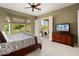 Bright bedroom with backyard views, a TV, and access to a patio at 12904 W Dale Ln, Peoria, AZ 85383