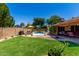 Well-maintained backyard featuring a sparkling pool, a covered patio, and lush greenery for outdoor enjoyment at 15256 N 62Nd Ave, Glendale, AZ 85306