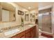 Elegant bathroom featuring dual sinks, granite countertops, and a glass-enclosed shower at 15256 N 62Nd Ave, Glendale, AZ 85306