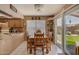 Dining area adjacent to kitchen, with wooden table set and sliding door to backyard at 15256 N 62Nd Ave, Glendale, AZ 85306
