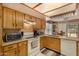 Well-lit kitchen featuring oak cabinetry, granite countertops, and white appliances at 15256 N 62Nd Ave, Glendale, AZ 85306