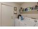 Functional laundry area features a washer, dryer, storage shelves, and ample counter space for folding at 15256 N 62Nd Ave, Glendale, AZ 85306