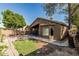 Inviting backyard featuring a covered patio, lush green lawn, and mature shade trees, ideal for outdoor living at 16242 W Maui Ln, Surprise, AZ 85379