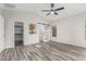 Bedroom featuring hardwood floors, ceiling fan, natural light, and a sliding barn door to the en suite bathroom at 16242 W Maui Ln, Surprise, AZ 85379