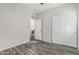 Bright bedroom featuring grey wood-look flooring, a closet, and an open doorway at 16242 W Maui Ln, Surprise, AZ 85379