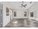 Bedroom with hardwood floors, a ceiling fan, ample natural light, and a sliding barn door to the en suite bathroom at 16242 W Maui Ln, Surprise, AZ 85379