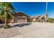 Attractive single-level home featuring a well-maintained yard, lush palm tree, and a two-car garage at 16242 W Maui Ln, Surprise, AZ 85379