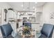 Bright kitchen and dining area featuring white cabinets, stainless steel appliances, and stylish pendant lighting at 16242 W Maui Ln, Surprise, AZ 85379