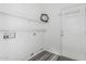 Functional laundry room with white walls, wood-look floors, and shelving at 16242 W Maui Ln, Surprise, AZ 85379
