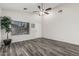 Bright living room featuring modern flooring, a ceiling fan, and a large window at 16242 W Maui Ln, Surprise, AZ 85379