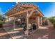 Outdoor backyard patio with pergola, seating, and barbecue area, ideal for outdoor entertaining and relaxation at 16365 N 138Th Ave, Surprise, AZ 85374