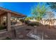 Lush backyard features a covered patio, gravel landscaping, and mature trees, perfect for outdoor living at 16365 N 138Th Ave, Surprise, AZ 85374