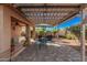 Charming backyard patio featuring a pergola, dining set, lush landscaping, and outdoor cooking area at 16365 N 138Th Ave, Surprise, AZ 85374
