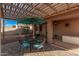 Relaxing backyard patio featuring a shaded pergola, comfortable seating, and a well-maintained yard at 16365 N 138Th Ave, Surprise, AZ 85374