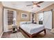 Calm bedroom features a ceiling fan, wood floors, and a sliding barn door to bathroom at 16365 N 138Th Ave, Surprise, AZ 85374