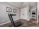 Bedroom featuring a treadmill, gray walls, and a view into another room with light-colored furnishings at 16365 N 138Th Ave, Surprise, AZ 85374