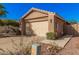 Tan single-story home with a two-car garage, desert landscaping and tile roof at 16365 N 138Th Ave, Surprise, AZ 85374