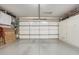 Spacious garage with epoxy flooring, built-in storage cabinets, and ample room for vehicles at 16365 N 138Th Ave, Surprise, AZ 85374