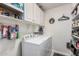 Well-organized laundry room with white cabinets, shelves, and a modern washer and dryer at 16365 N 138Th Ave, Surprise, AZ 85374