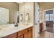 Bathroom vanity with decorative fixtures and an entrance to another room at 16758 W Apache St, Goodyear, AZ 85338