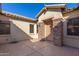 Inviting front patio with textured concrete, stone pillars and trim, with a secure front door at 16758 W Apache St, Goodyear, AZ 85338