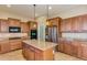 Bright kitchen showcasing a central island, stainless steel refrigerator, and wooden cabinets at 16758 W Apache St, Goodyear, AZ 85338