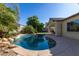 Inviting pool with rock features and lush landscaping and a large deck for entertaining at 16758 W Apache St, Goodyear, AZ 85338