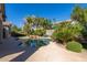 Private pool surrounded by lush tropical landscaping and an extended deck with mature trees at 16758 W Apache St, Goodyear, AZ 85338